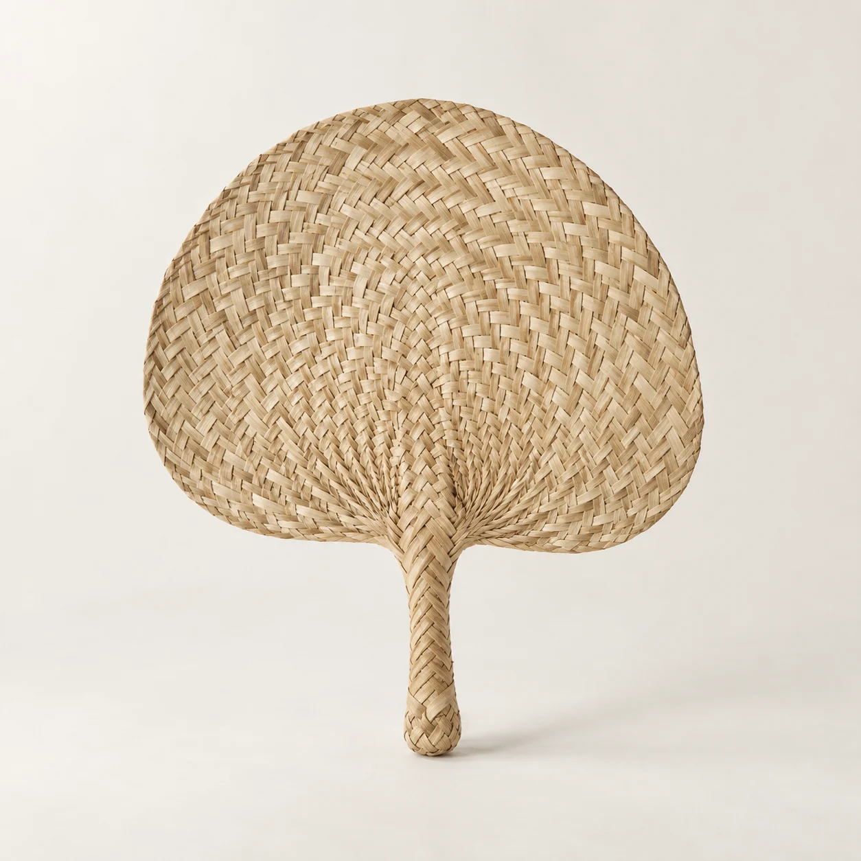 Abanico de hoja trenzada. Imagen ilustrativa generada por IA; materiales: fibra vegetal.
