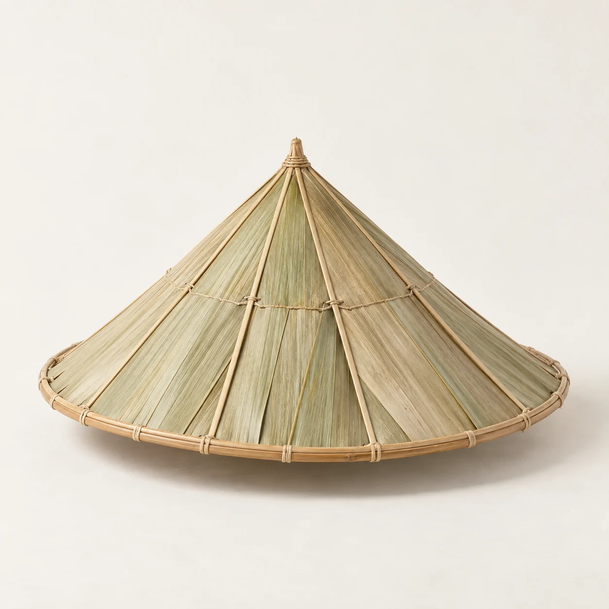 Sombrero cónico de hoja. Imagen ilustrativa generada por IA; materiales: hoja de palma y bambú.
